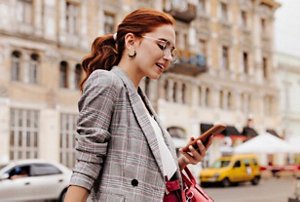 Redheaded woman texting on her mobile phone
