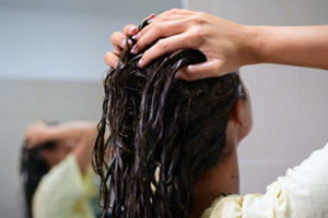 Brunette woman washing her hair in the shower after dyeing her hair