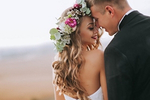 Bride with wavy hair and a flower crown kissing her groom