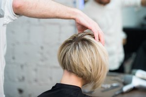 Woman with graduated pixie cut having her hair styled at the hairdressers