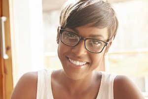 Stunning woman wearing a white top with a pixie cut with a fringe 