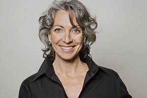 woman with curly grey hair looking into the camera
