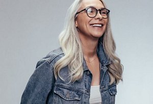 woman with grey wavy hair smiling to camera 