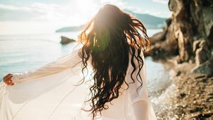 Brunette woman with long, tousled beach waves at the beach
