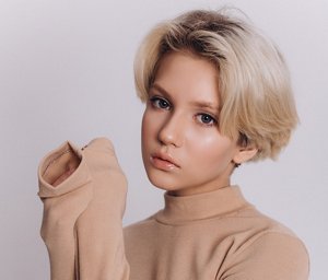 Young woman with a blonde bixie cut with 90s style fringe