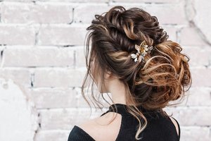Bridesmaid with a romantic braided bun hairstyle with decorative clips