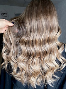 Bronde balayage hair against a dark grey background