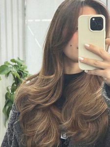 Young woman with a butterfly cut taking a selfie in a mirror using her phone