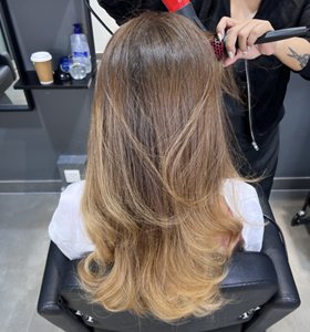 Woman with chocolate to toffee sombré hair with her stylist