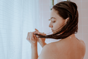 Woman washing her hair with warm water