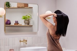 Woman running her hands through her silky hair after using a lamellar water rinse