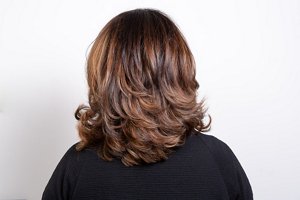 Woman with dark red hair with a layered shoulder length cut