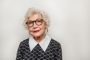 Woman in her 70s with a tousled, styled curly pixie cut