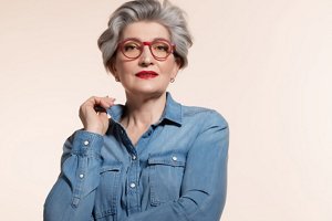 Sophisticated woman in her 70s with a styled, swept-back haircut