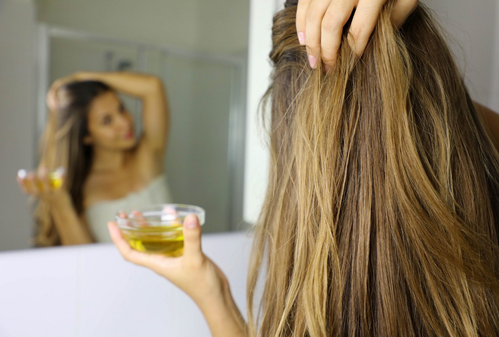 Blonde Hair girl using essential oil for hair care treatment