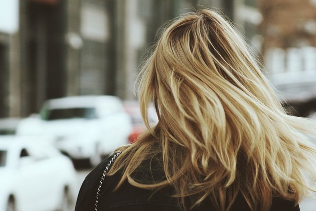 Woman with long blonde hair walking down the street