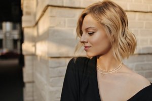 Blonde woman with a mid-length choppy bob styled into waves