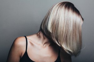 Blonde woman with long, asymmetrical bob styled with discreet blonde highlights