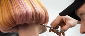 Orange and pink bob being cut by hairdresser with scissors