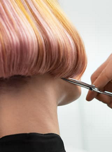 Orange and pink bob being cut by hairdresser with scissors