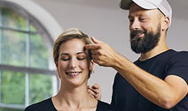 Stylist styling woman who holds styling product in her hands