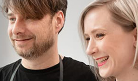 Male and female stylist partners hugging and smiling