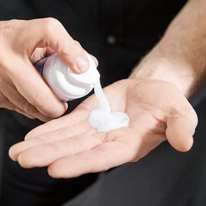 Person putting hair styling gel into hands