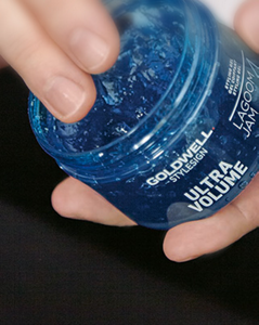 Hands holding Goldwell product Ultra Volume