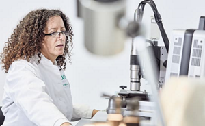Female lab assistant in front of microscope
