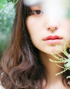 Asian woman with brown hair surrounded by plants