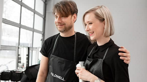 Male and female stylist partners hugging and smiling