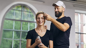 Stylist styling woman who holds styling product in her hands