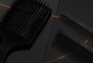 Black VARIS paddle hair brush bristles in front of a dark background