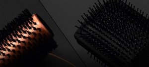 Black VARIS paddle hair brush bristles in front of a dark background