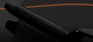 Black VARIS curling iron in front of a dark background