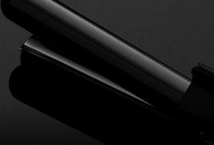 Black VARIS curling iron in front of a dark background